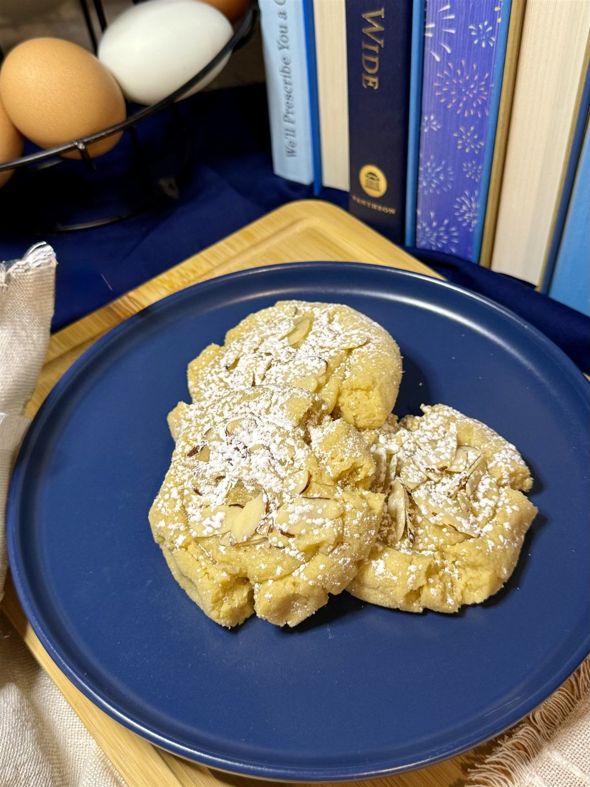 Almond cookies topped with sliced almonds and powdered sugar