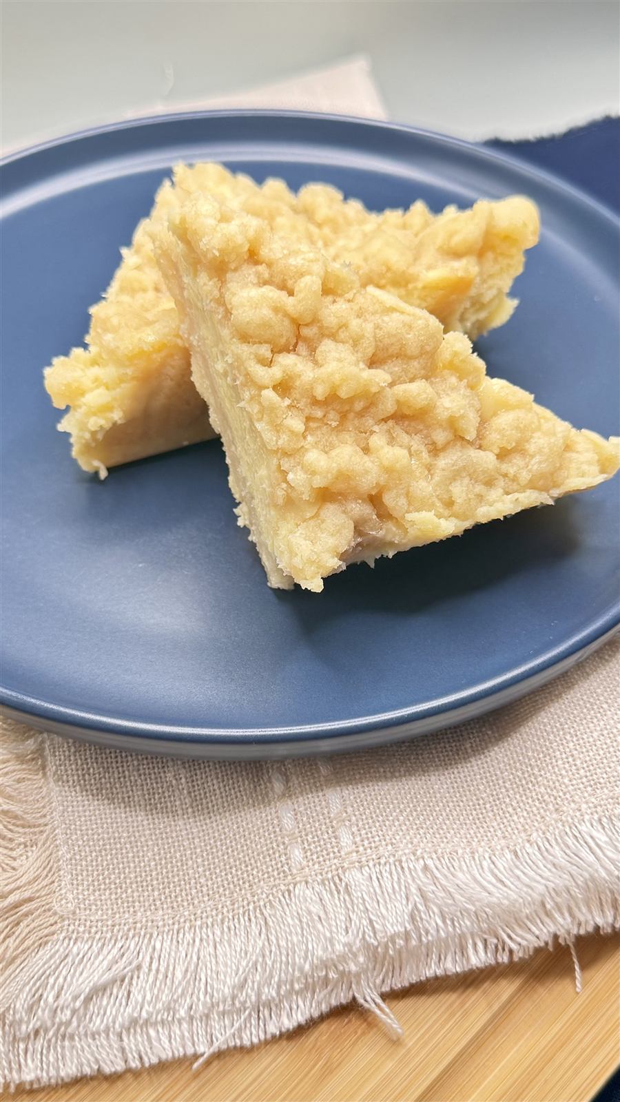 Creamy lemon bars cut into triangles on a blue plate